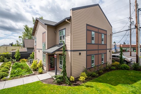 the front of a house with a sidewalk and grass
